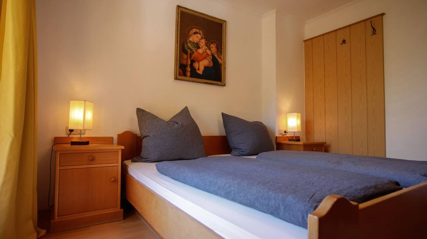 Schlafzimmer mit Madonna-Bild und Nachttischlampen