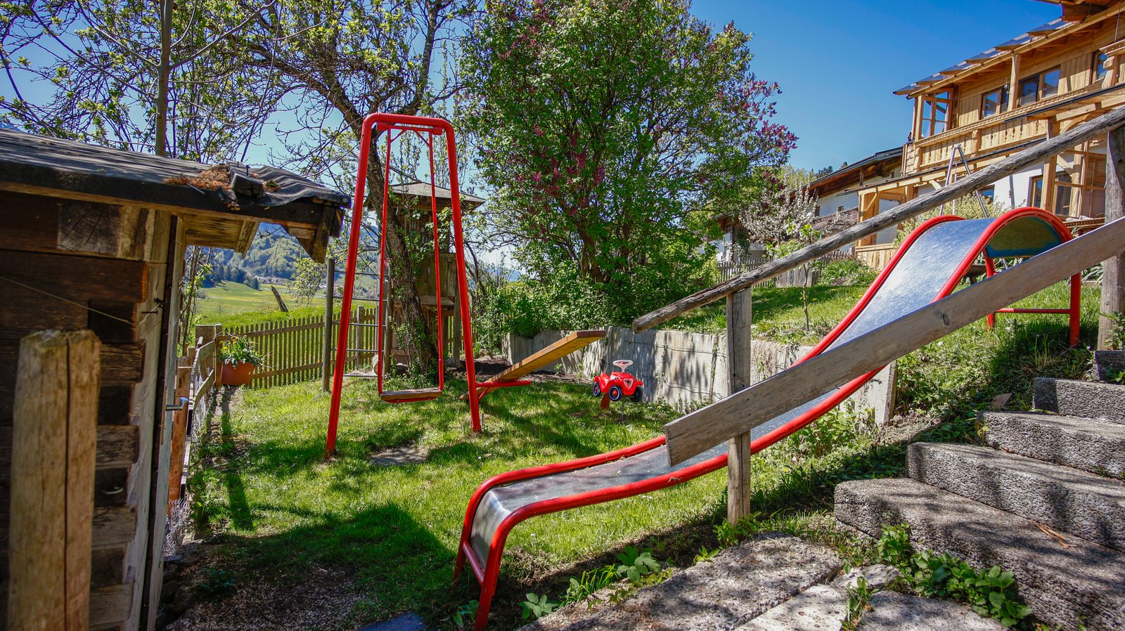 Spielplatz mit Rutsche, Schaukel und Bergblick